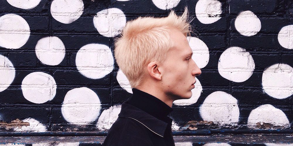 Blonde man against polka dot wall